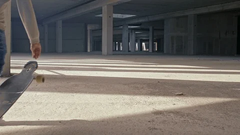 A young longboarder drives zigzag between the concrete columns while the camera Stock Footage 90209144