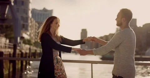 Young Love Couple dancing at sunset in front of Port City Stock Footage 78986249