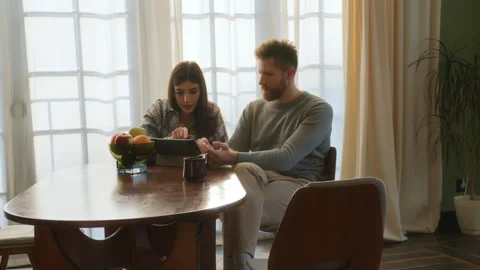 Young love sit at table and use tablet Stock Footage 266810502