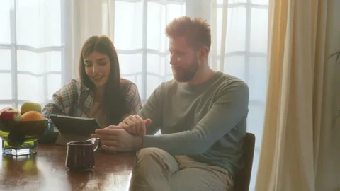 Young love sit at table and use tablet Video stock 266810817