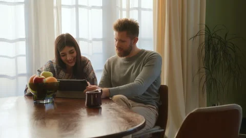 Young love sit at table and use tablet Stock Footage 266810989
