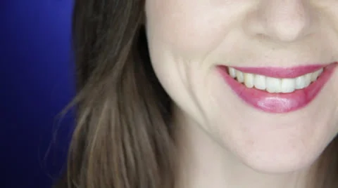 Young lovely lassie does grin smile on a blue background Stock Footage 22845137