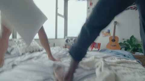 Young Lovers Having Fun and Playing Pillow Fight in Bedroom Stock Footage 236688645