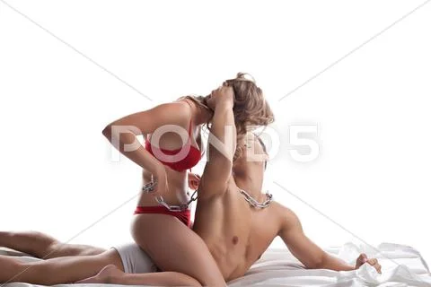 Young lovers play in bed with chain - sexual games Stock Photos
