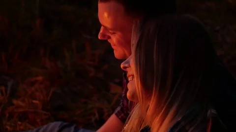 Young lovers smiling an night fire light Stock Footage 82545313