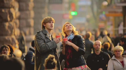 The young lovers with tea cups above the people crowd, REAL TIME Video stock 32547942