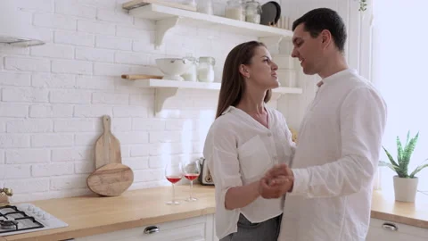 Young loving couple dancing and smiling while standing in home kitchen room spbi Stock Footage 166015677