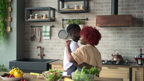 Young loving couple dancing and showing love while cooking dinner in home Stock Footage 166272457