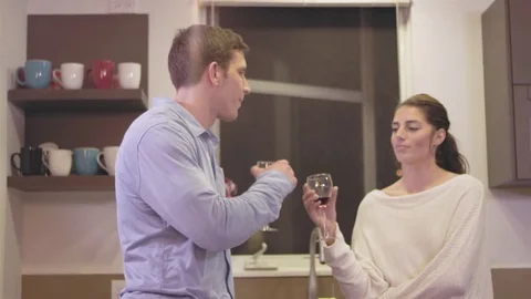 Young loving couple having a conversation in a kitchen while drinking wine Stock Footage 83021145