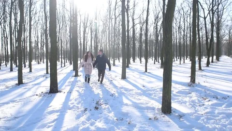 Young loving couple having fun in snowy park Видео 81736805