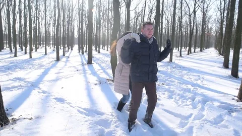 Young loving couple having fun in snowy park Stock Footage 81737327