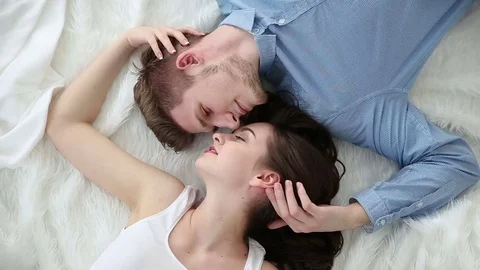 Young loving couple lying on bed at home Stock Footage 76244813
