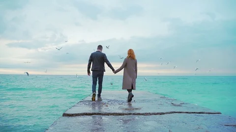 couple holding hands in rain