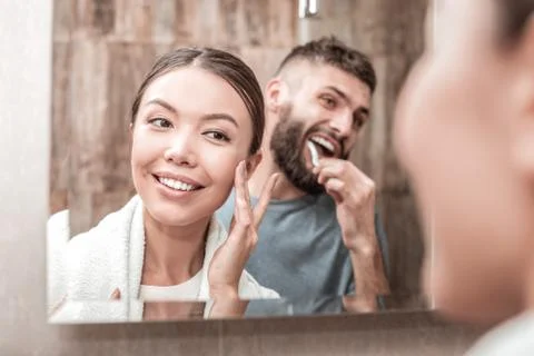 Young loving couple standing in front of mirror together Stock Photos
