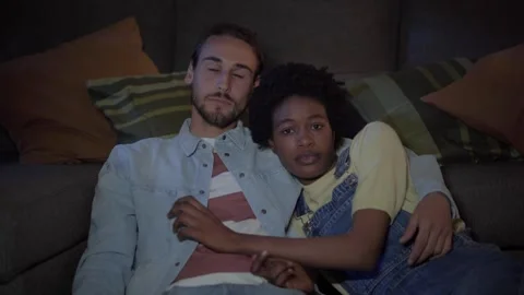 Young loving multi-ethnic couple watching movies or series TV relaxing sitting Stock Footage 273181657