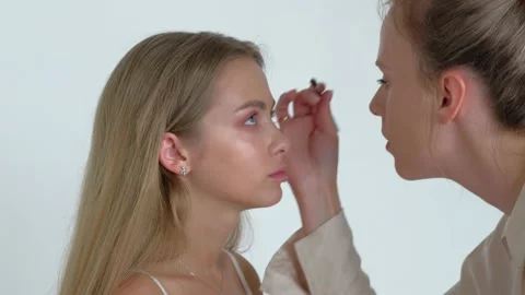 Young Makeup Artist Doing Makeover To Pretty Model Stock Footage 158640925