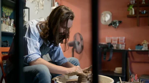 Young making a piece of clay molding calmly and meticulously Stock Footage 256878474