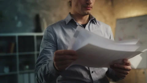 Young male accountant reading documents in office, analyzing company income Stock Footage 340960998