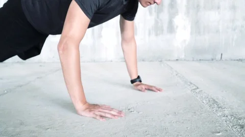Young male athlete doing push-ups in a grungy space with concrete floor Stock Footage 112655356