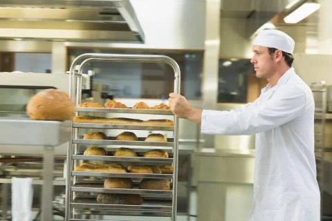 Young male baker pushing a trolley Stock Photos