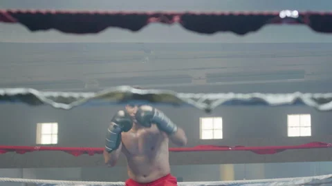 Young male boxer doing shadow fight in boxing gym Video stock 181840105