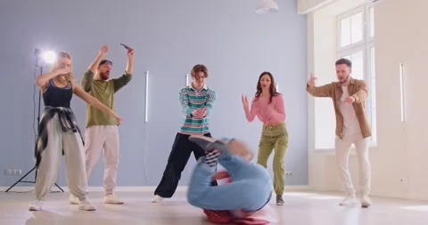 Young male breakdancer performing in front of his friends at modern dance studio Stock Footage 333219640