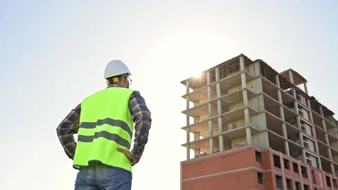 Young male builder engineer architect foreman with beard straightens his white Stock Footage 204842334