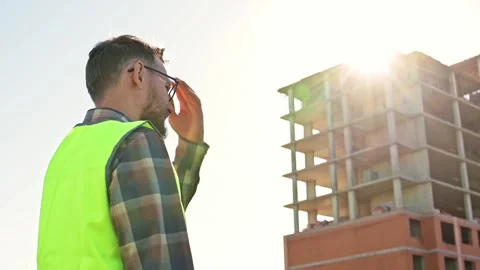 Young male builder engineer architect foreman with beard puts protective white 動画素材 206023418