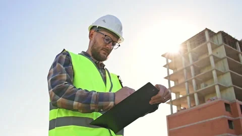 Young male builder engineer architect foreman designer holds black folder in Stockbeeldmateriaal 206023550