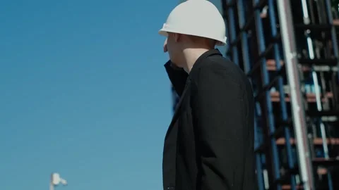 Young male builder engineer architect foreman in protective helmet stands with h Vidéo 249263209