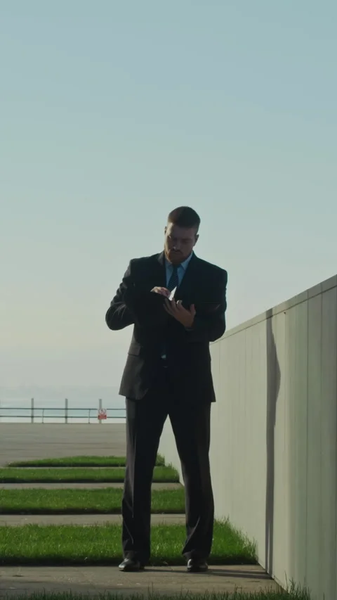 Young Male CEO Looking Through his Paper Documents Outside in Business Center Stock Footage 303627650