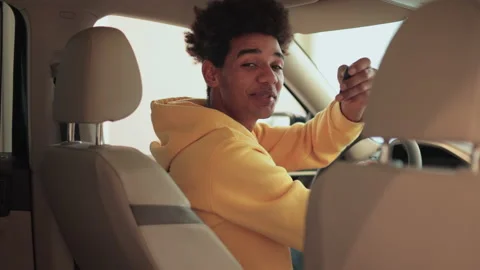 Young male client is sitting inside new car and showing keys in dealership Stock Footage 194417580