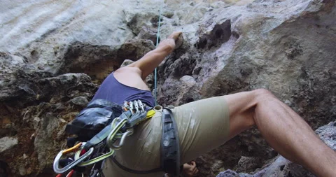 Young male climbing on limestone cliffs mountain, on Railay Beach Thailand. Slow Stock Footage 201095299