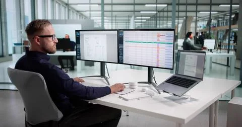 Young Male Coder Using Spreadsheet To Monitor Medical Billing Data. Accountan 스톡 사진