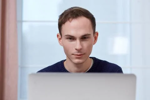 A young male computer programmer working at a computer. Stock Photos