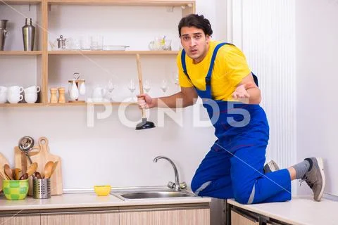 Young male contractor repairing tap at home Stock Photos