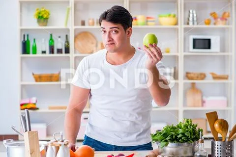 Young Male Cook Working In The Kitchen