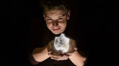 Young male with cupped hands performing a magic spell. Stock Footage 110324455
