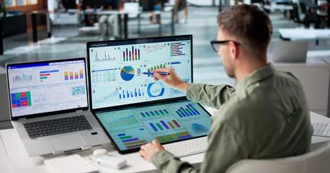 Young Male Data Analyst Focused On Monitoring Financial Metrics On Computer S Stock Photos