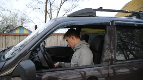 A young male driver puts on a face mask and gloves in the car Stock Footage 131143436