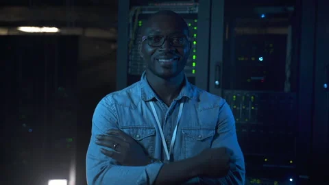 Young male engineer posing for camera and smiling during day or night at data Stock Footage 164714482