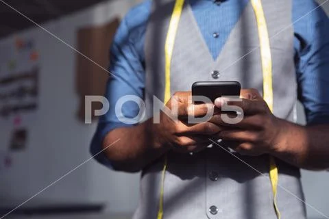 Young male fashion student using smartphone at college Stock Photos