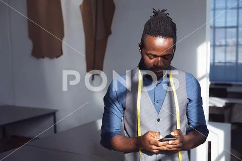 Young male fashion student using smartphone at college Stock Photos
