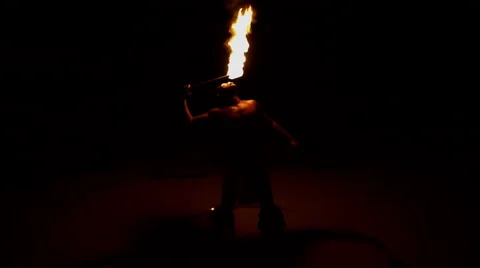 Young male Fire Eater performing with spinning Flaming torches an Art form  Stock Footage 68077088