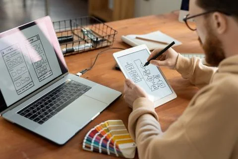 Young male freelance software developer holding stylus over tablet screen 스톡 사진