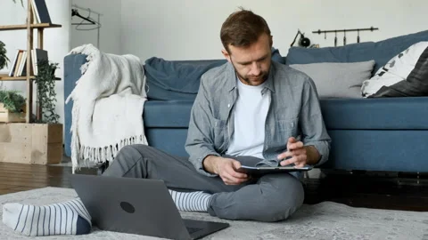 A Young Male Freelancer Makes Notes in A Magazine, A Freelancer Works At Home Stock Footage 156964111