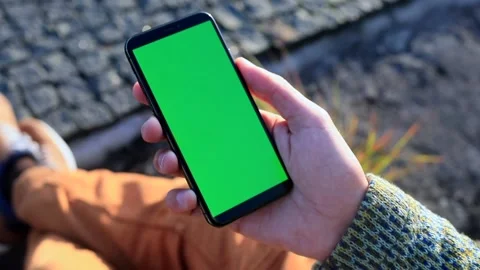 Young male hand using smartphone with blank green screen. Sunset sunlight rising 스톡 동영상 165825762