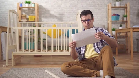 Young male has problems with the Assembly of furniture Stock Footage 124747042