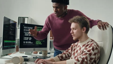 Young Male IT Engineer Pair Programming with Colleague at Compute Desk Stock Footage 330129127