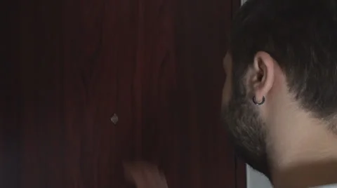 Young Male Looking Through Eye Hole Medium-Shot Stock Footage 35458114